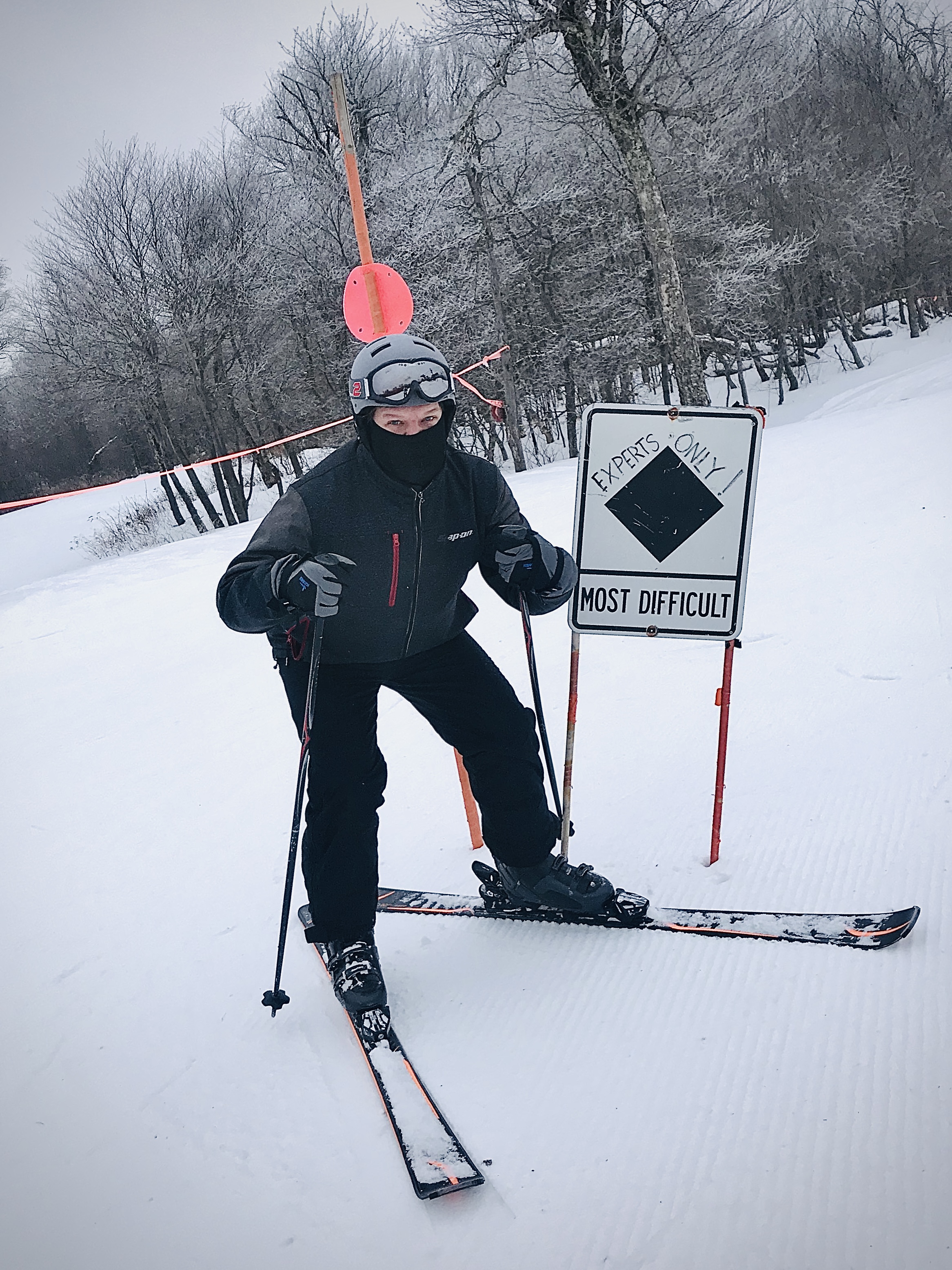 Matthew skiing beside an expert-only trail sign